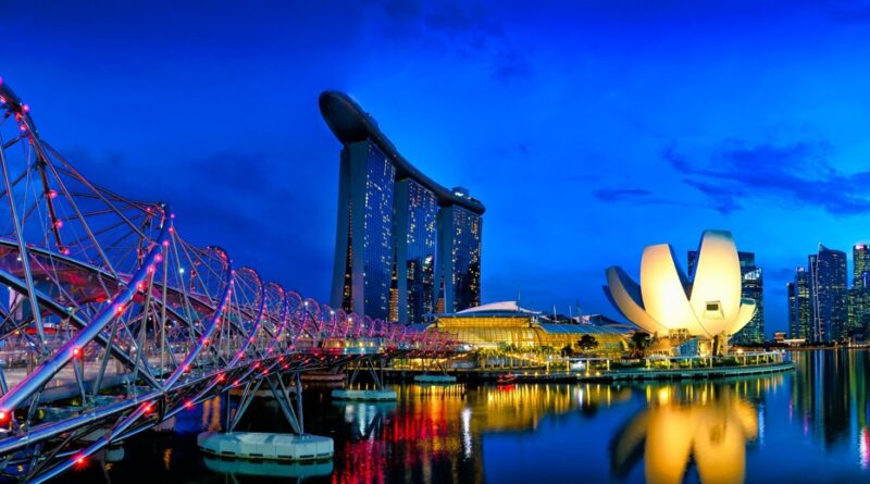 Panorámica nocturna de Singapur con el Helix Bridge y Marina Bay Sands, representando la arquitectura de la voluntad y el estilo de vida bleisure.
