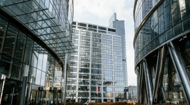 Perspectiva contrapicada de edificios corporativos modernos de cristal y acero, arquitectura financiera de Family Offices y holdings de inversión en Latinoamérica
