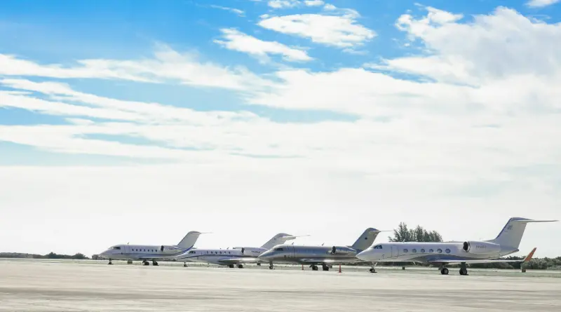 Línea de aviones privados corporativos en la pista de una terminal exclusiva, representando el arbitraje y la migración logística quirúrgica de empresarios mexicanos hacia Estados Unidos durante el mundial.